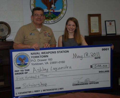 Captain Lowell Crow, Commanding Officer, Naval Weapons Station (WPNSTA) Yorktown, presents Ashley Laginestra with $500 as the 2011 recipient of the Nick and Mary Mathew's Scholarship. Laginestra, the daughter of MMCS Jody Reynolds of the Naval Submarine Torpedo Facility, is a senior at Bruton High School and will be attending Liberty University in the fall. This TRICARE change will affect young adult children of military personnel. (U.S. Navy photo)