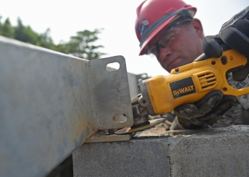 Pennsylvania National Guard Senior Master Sgt. Ronald Hinsey, 201st Rapid Engineer Deployable Heavy Operational repair Squadron Engineers structures superintendent, grinds a mounting plate to size for a new medical clinic. Photo by Senior Airman Dillon Davis