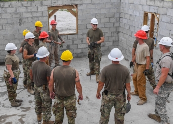Army 2nd Lt. Gabriel Kern, platoon leader assigned to the 276th Engineer Company, Missouri Army National Guard, does a closing brief after a concrete pour at a construction site in Linden, Guyana. Photo by Senior Airman Derek Seifert.