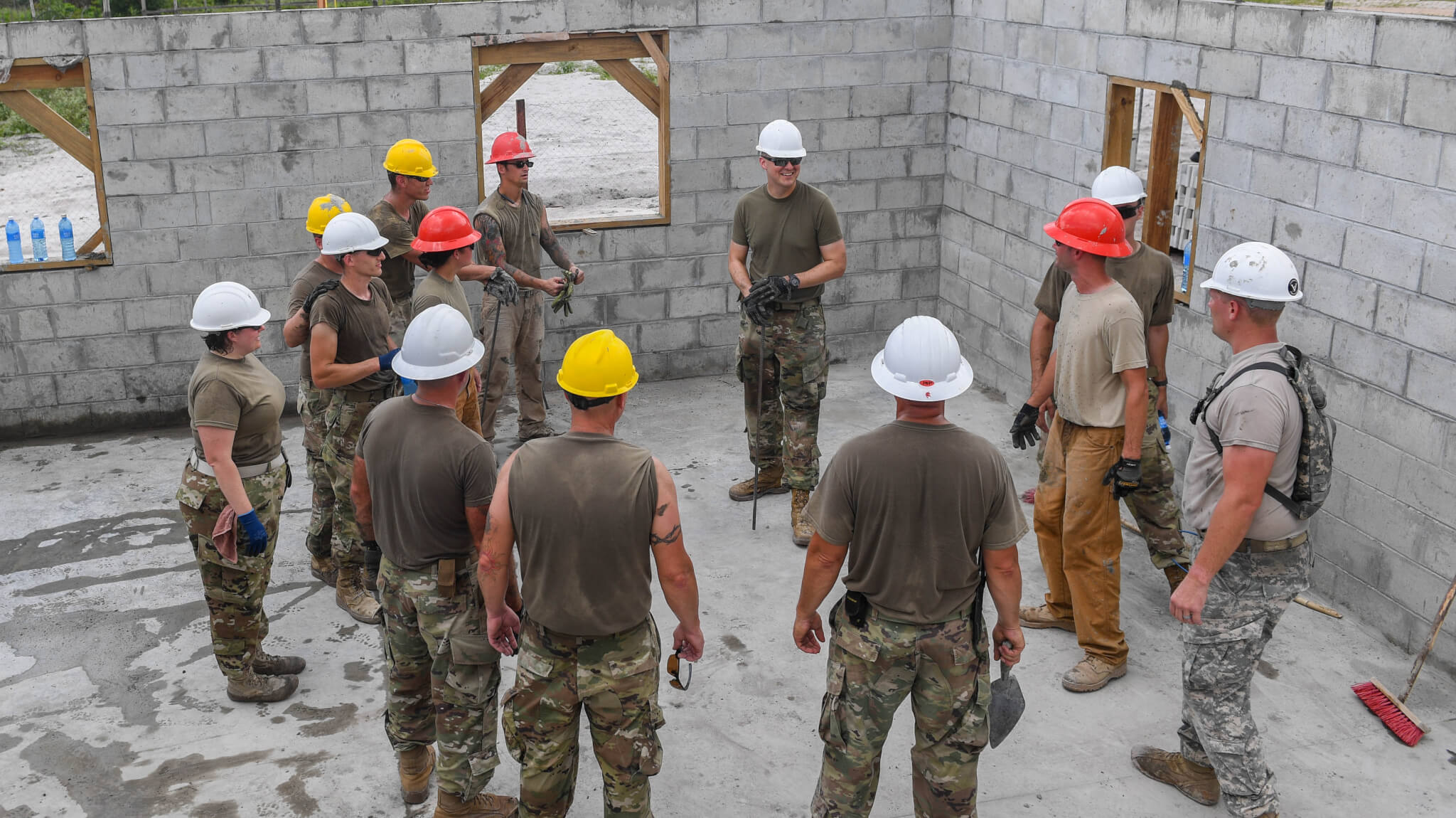 Army 2nd Lt. Gabriel Kern, platoon leader assigned to the 276th Engineer Company, Missouri Army National Guard, does a closing brief after a concrete pour at a construction site in Linden, Guyana. Photo by Senior Airman Derek Seifert.
