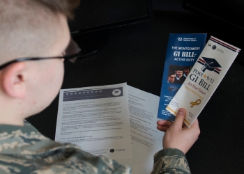 Airman Dalton Shank, 5th Bomb Wing public affairs specialist, reads pamphlets on the Montgomery GI Bill and the Post-9/11 GI Bill. Photo by Airman 1st Class Alyssa M. Akers.