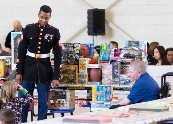 A Marine engages with military kids at a 2018 Toys for Tots event with First Lady Melania Trump. Photo by Trish-Alegre Smith.