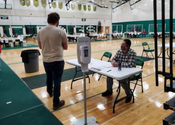 Pvt. Will Reas of the 173rd Brigade Engineer Battalion checks voters into a polling place May 12, 2020, in Rhinelander, Wisconsin. Approximately 160 Wisconsin National Guard members mobilized to state active duty as poll workers supporting the 7th Congressional District special election in northern Wisconsin. (Photo courtesy of the Wisconsin National Guard)