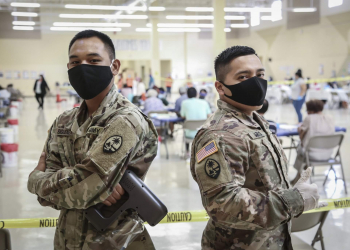 Pvt. 1st Class Shane Siguenza, left, and Spc. Christian Marzo of the Guam National Guard assist with traffic flow and sanitation at the COVID-19 vaccination site in Dededo.