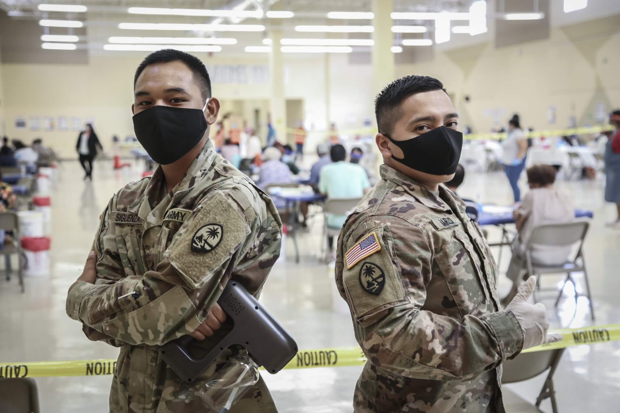 Pvt. 1st Class Shane Siguenza, left, and Spc. Christian Marzo of the Guam National Guard assist with traffic flow and sanitation at the COVID-19 vaccination site in Dededo.