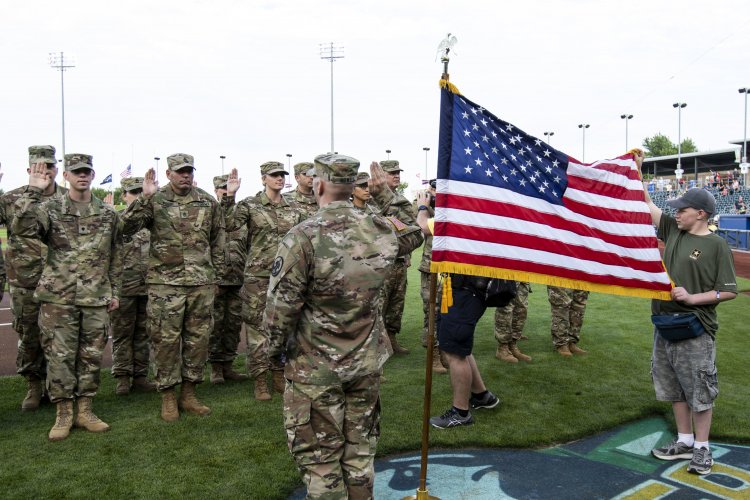 Army Reserve soldiers, with various units in Nebraska, take the oath of enlistment during a mass reenlistment ceremony at an Omaha Storm Chasers baseball game in Papillion, Nebraska, in 2018. The formation consists of 22 soldiers and is the first of its kind in Nebraska. Photo by Sgt. Christopher Jackson.