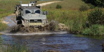 Joint Light Tactical Vehicle driver's training students learn about the fording capabilities of the JLTV while driving through a small river at Fort McCoy, Wis., Sept. 1, 2021. Photo by Sgt. Bill Washburn