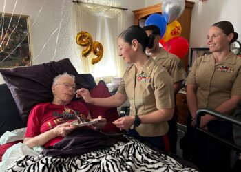 Marine Corps Maj. Shannon Potts, a manpower officer assigned to Headquarters Company, 23rd Marine Regiment, 4th Marine Division helps retired Marine Corps Cpl. Lou 'Mama Lou' Keller eat her birthday cake during Mama Lou's 99th birthday celebration, March 30, 2024, in San Jose, California. Image courtesy of 23rd Marines