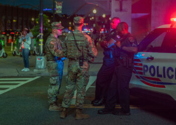 U.S. Army 2nd Lt. Harry Siegel and Sgt. 1st Class Nikolay Bashko talk with Metropolitan Police Department officers near Nationals Park, Aug. 19, 2025. The D.C. National Guard is uniquely commanded by the President of the United States through the Secretary of Defense. Guard members were activated under the Joint Task Force–District of Columbia as part of the D.C. Safe and Beautiful Task Force to support District and federal partners in safeguarding property and ensuring the functions of government. (U.S. Army Photo by Spc. Carrol Walter Hughes IV)
