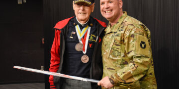 103-year-old veteran Don Halverson cuts the cake with help from Brig, Gen. Joseph Sharkey