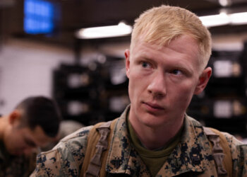 U.S. Marine Corps Cpl. Nathaniel Hill speaks to another Marine during a gear issue at Fort Devens, Massachusetts, Dec. 14, 2025. Hill is a rifleman with Charlie Company, 1st Battalion, 25th Marine Regiment. Marines took part in this event as an ongoing effort to prepare and maintain readiness for upcoming training and operations. (U.S. Marine Corps photo by Lance Cpl. Priscilla Flores)