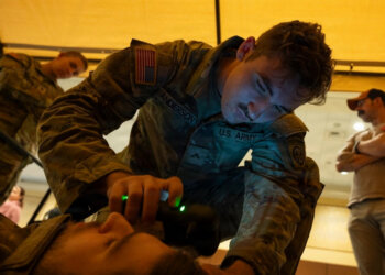 A combat medic assigned to 3rd Battalion, 319th Field Artillery Regiment, 82nd Airborne Division, operates an intercranial hemorrhage assessment device during a Soldier touchpoint event. Battlefield traumatic brain injury assessments and a refreshed Warfighter Brain Health initiative were focal points of discussion during the 2026 Annual Brain Health Symposium, hosted by the Traumatic Brain Injury Center of Excellence. Photo by T. T. Parish