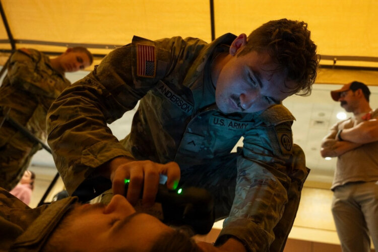A combat medic assigned to 3rd Battalion, 319th Field Artillery Regiment, 82nd Airborne Division, operates an intercranial hemorrhage assessment device during a Soldier touchpoint event. Battlefield traumatic brain injury assessments and a refreshed Warfighter Brain Health initiative were focal points of discussion during the 2026 Annual Brain Health Symposium, hosted by the Traumatic Brain Injury Center of Excellence. Photo by T. T. Parish